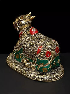 Brass Nandi figure with detailed engraving, red medallions and green inlay, angled view