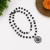 Silver-toned Yantra pendant on black bead necklace with small round bead links