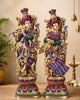 Brass Radha Krishna sculpture pair, standing figures with jeweled crowns and colorful attire.