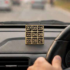 Kuber Sankhya Yantra on dashboard, gold number squares on dark tabletop base