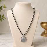 Black bead mala necklace with silver cap and circular Yantra pendant on front