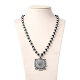 Black bead mala necklace with silver cap and square-backed circular Yantra pendant