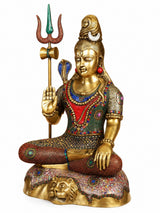 Brass Lord Shiva statue seated, blessing hand raised with trident; jeweled multicolor robe