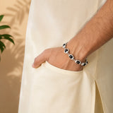 Bracelet on wrist: silver links with dark black beads and metal caps