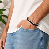 Ebony wood bead bracelet on wrist with silver chain and clasp