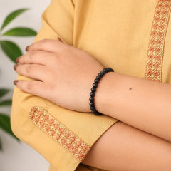 Kids ebony wood beaded bracelet on wrist, round black beads