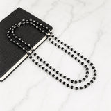Black beaded necklace with silver-toned accents and matching bracelet, loop clasp