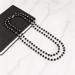 Black beaded necklace with silver-toned accents and matching bracelet, loop clasp
