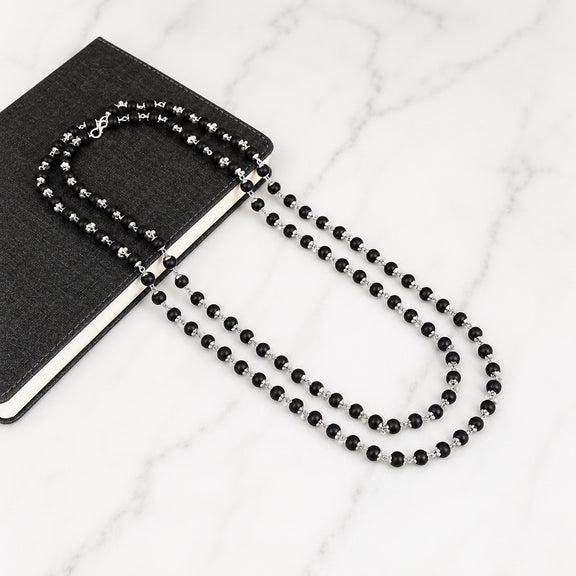 Black beaded necklace with silver-toned accents and matching bracelet, loop clasp