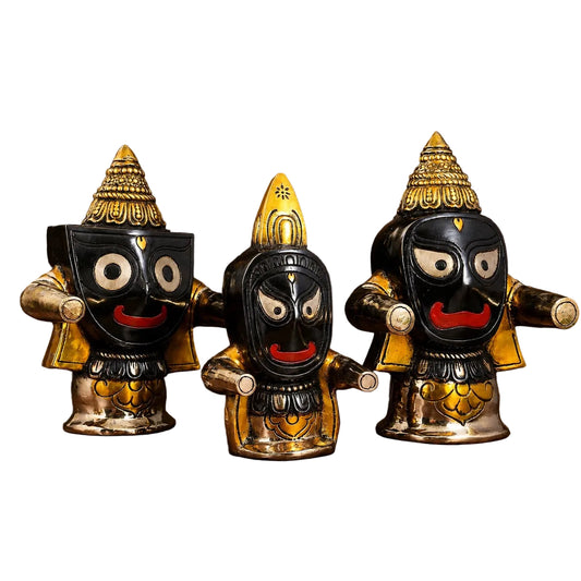 Three brass idol figures, front view, black faces with red smiles and gold crowns