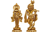 Brass Radha-Krishna idols shown from rear, holding accessories, ornate pedestal bases