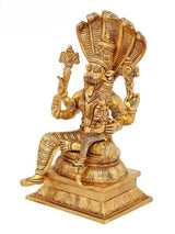 Brass Narasimha figure with raised hands, seated on decorated base, side view