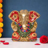 Brass Ganesha idol facing front, red fan-shaped earrings, jeweled crown