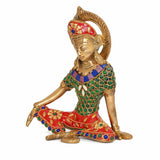 Brass Indra statue seated, ornate red crown, teal green patterned outfit with jeweled details.