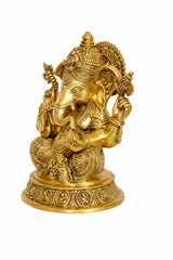 Golden Ganesha murti side view, trunk and facial details with raised hands