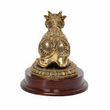 Brass Nandi bull idol with crown, seated on dark wooden base, rear view