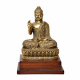 Brass Buddha statue seated in Abhaya mudra, detailed robe and golden finish