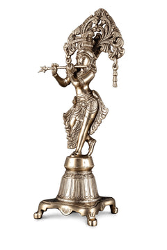 Brass Krishna idol side view with decorative arch, raised hand, detailed patterned attire