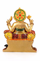 Back view brass Ganesha idol with circular motif, red and green cloth pattern