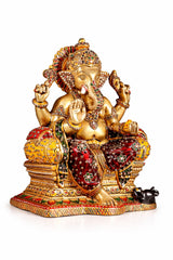 Brass Ganesha idol close-up with red patterned attire, jeweled ornaments, raised palms