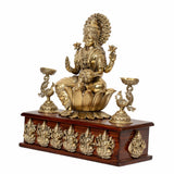 Lakshmi brass goddess seated on lotus with side peacock oil lamp holders on wooden base