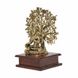 Brass Tara Devi statue in angled view with detailed tree canopy and wooden base
