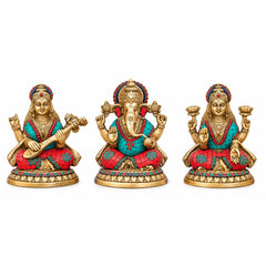 Three brass Hindu idols: Ganesha, Lakshmi, and Saraswati seated with red and blue details