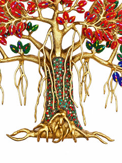 Brass tree trunk statue close-up with colorful inlaid panels and carved roots