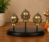 Brass Gauri/Parvati head idols on round dark base, three faces