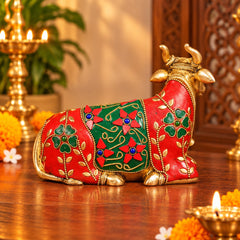 Brass Nandi bull idol with red and green stonework, side profile with upraised tail