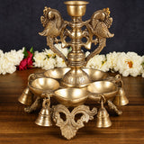 Ornate brass urli stand with multi-dip bowl and deity figure details