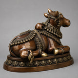 Brass brown reclining bull figure statue on circular base, detailed jewelry trim