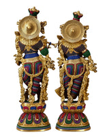 Brass Radha Krishna sculpture viewed from rear/side, with golden halos and jeweled crowns.