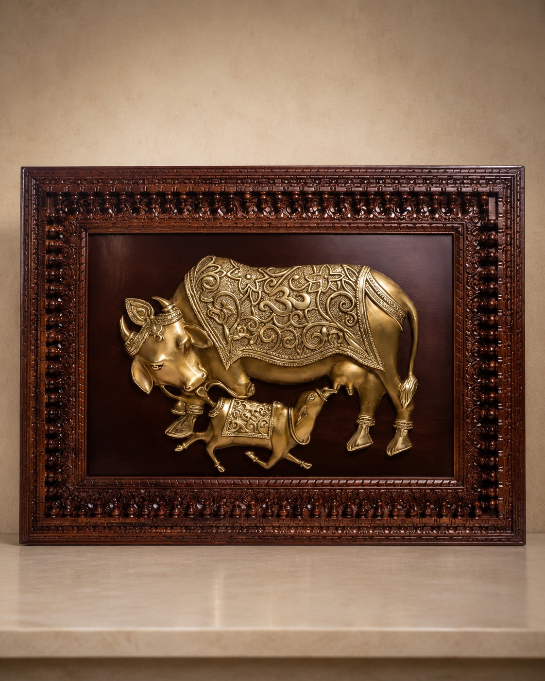 Brass cow and calf relief wall art inside richly carved wooden frame