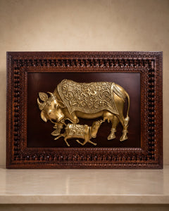 Brass cow and calf relief wall art inside richly carved wooden frame