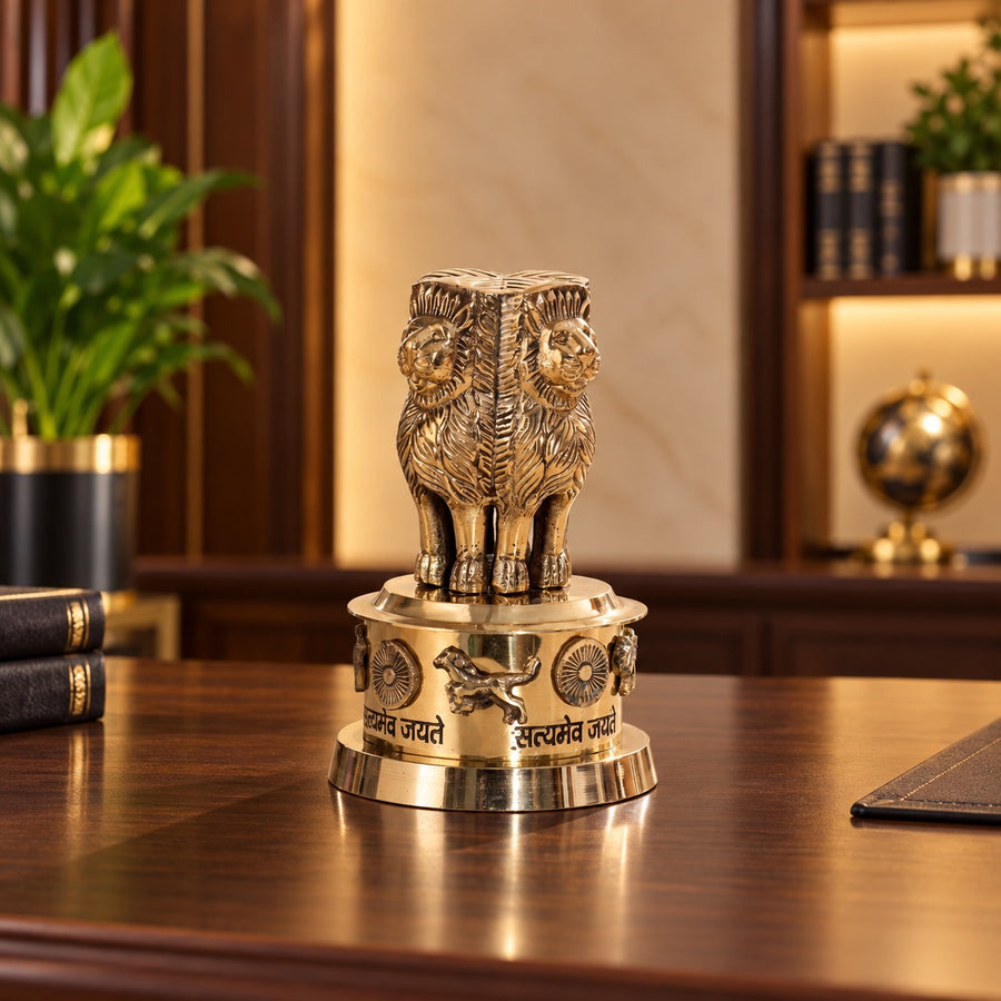 Brass Ashoka Pillar showpiece, shown on a desk with its four-lion capital and engraved base