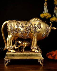 Brass engraved cow statue with calf, horned head, deity motifs, flat ornate stand