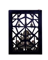 Back view of brass Ganesha idol and hanging bells within carved screen frame