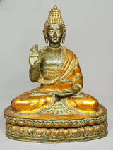 Seated brass Buddha statue with serene face, gilded robe, blessing hand and lap pose