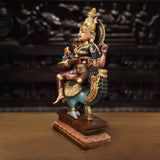 Brass Saraswati seated figure holding veena, side view on blue fish base
