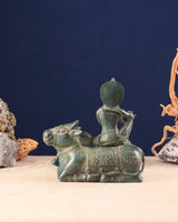 Bronze Krishna seated on cow figure, rear/side angle, ornate headdress and base