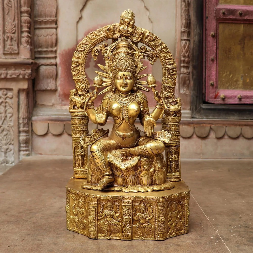 Brass sitting Maa Lakshmi idol, ornate arch and carved pedestal, 19 in
