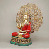 Seated Buddha statue facing side, red robe with gold patterns, tree canopy, green pedestal
