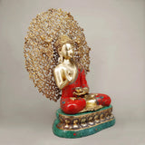Seated Buddha holding bowl, red robe, gold-tone face and hands, tree canopy, green base
