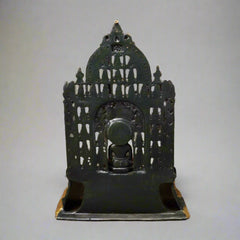 Dark brass Mahavir Swami idol back view, spiked arch frame over seated figure