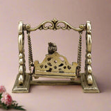 Brass Baby Krishna swing sculpture back view of pierced seat panel with chains
