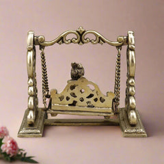 Brass Baby Krishna swing sculpture back view of pierced seat panel with chains