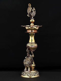 Brass peacock lamp with decorative top bowl and elephant figure at the base