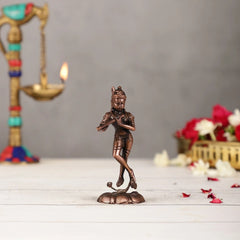 Copper Krishna statue, 4.5 in, side view with raised hand and flute-like instrument