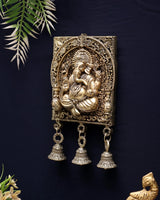 Brass Ganesh wall hanging: ornate square relief with arched halo and three bell charms